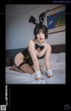 A woman in a bunny costume sitting on a bed.