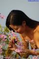 A naked woman in a field of pink flowers.